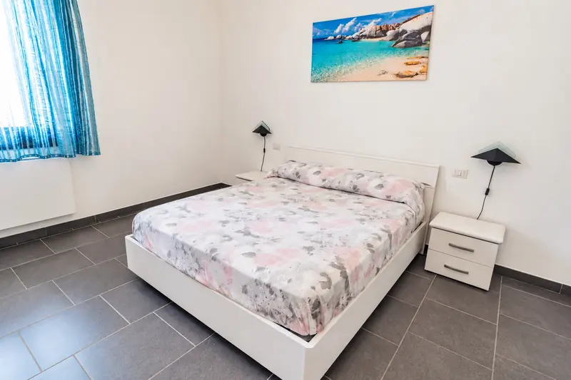 La camera matrimoniale con il letto e i comodini